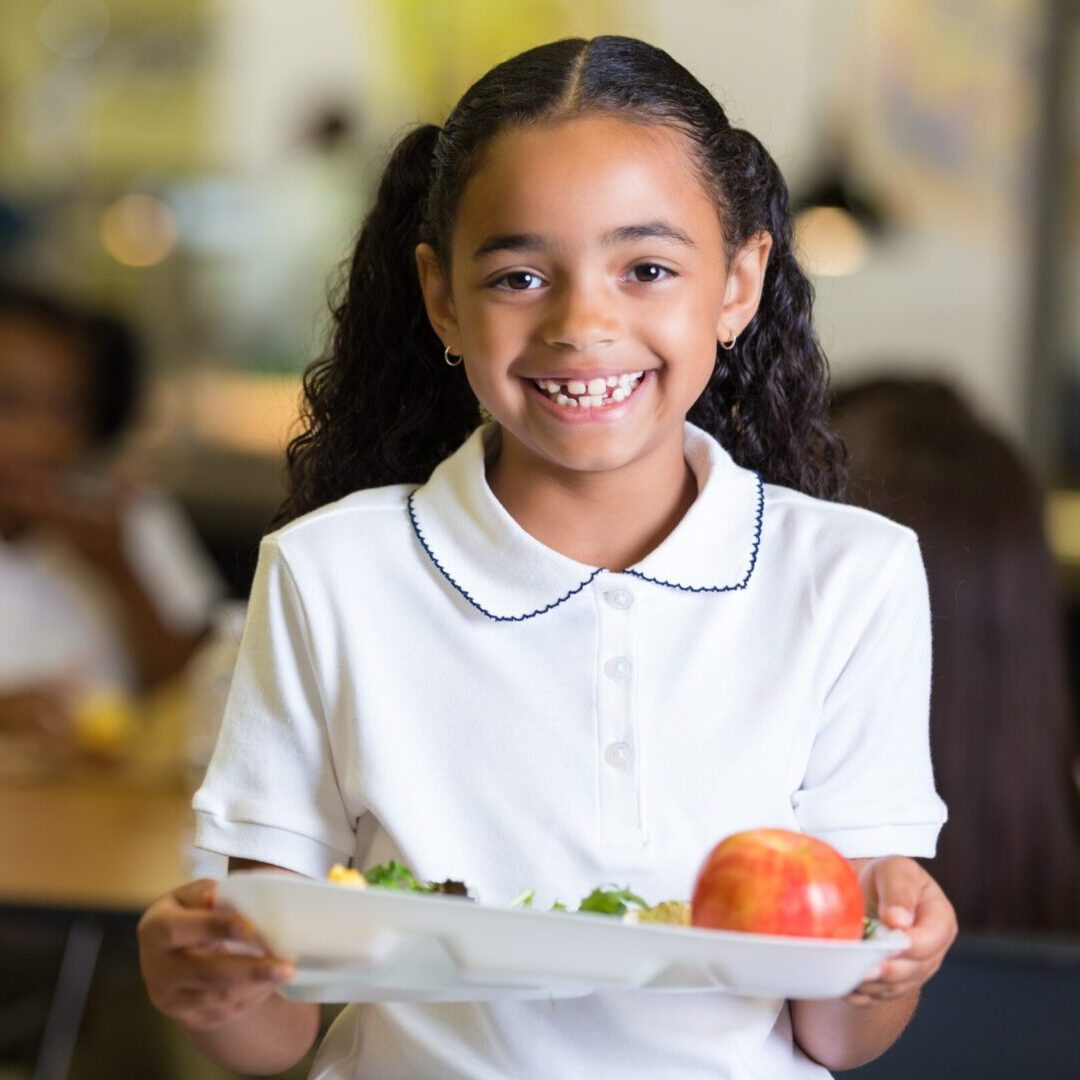 Cute little girl in school cafeteria with food tray